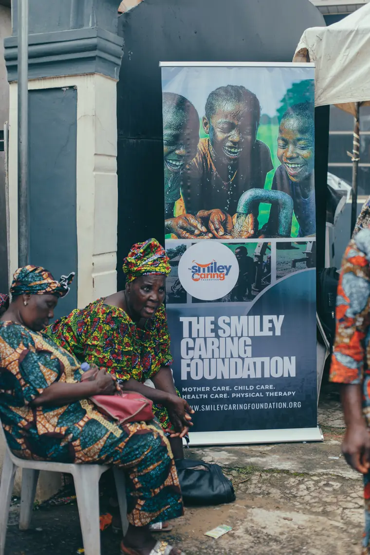 A resident at the Smiley Caring Foundation backdrop in Mushin.