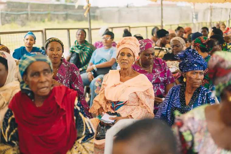 Elderly women waiting together at the relief event.