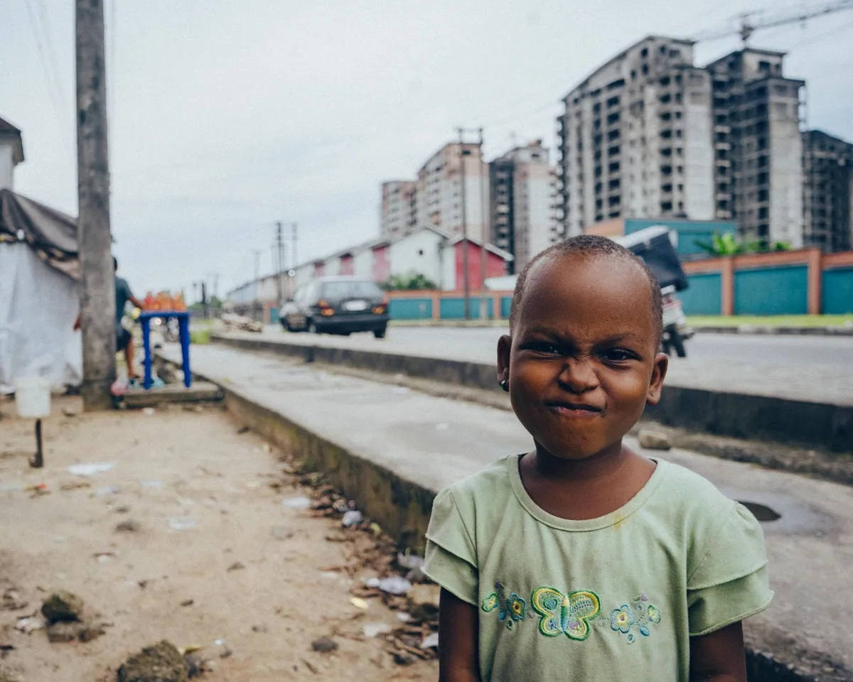 A young boy smiling on a street in Nigeria.