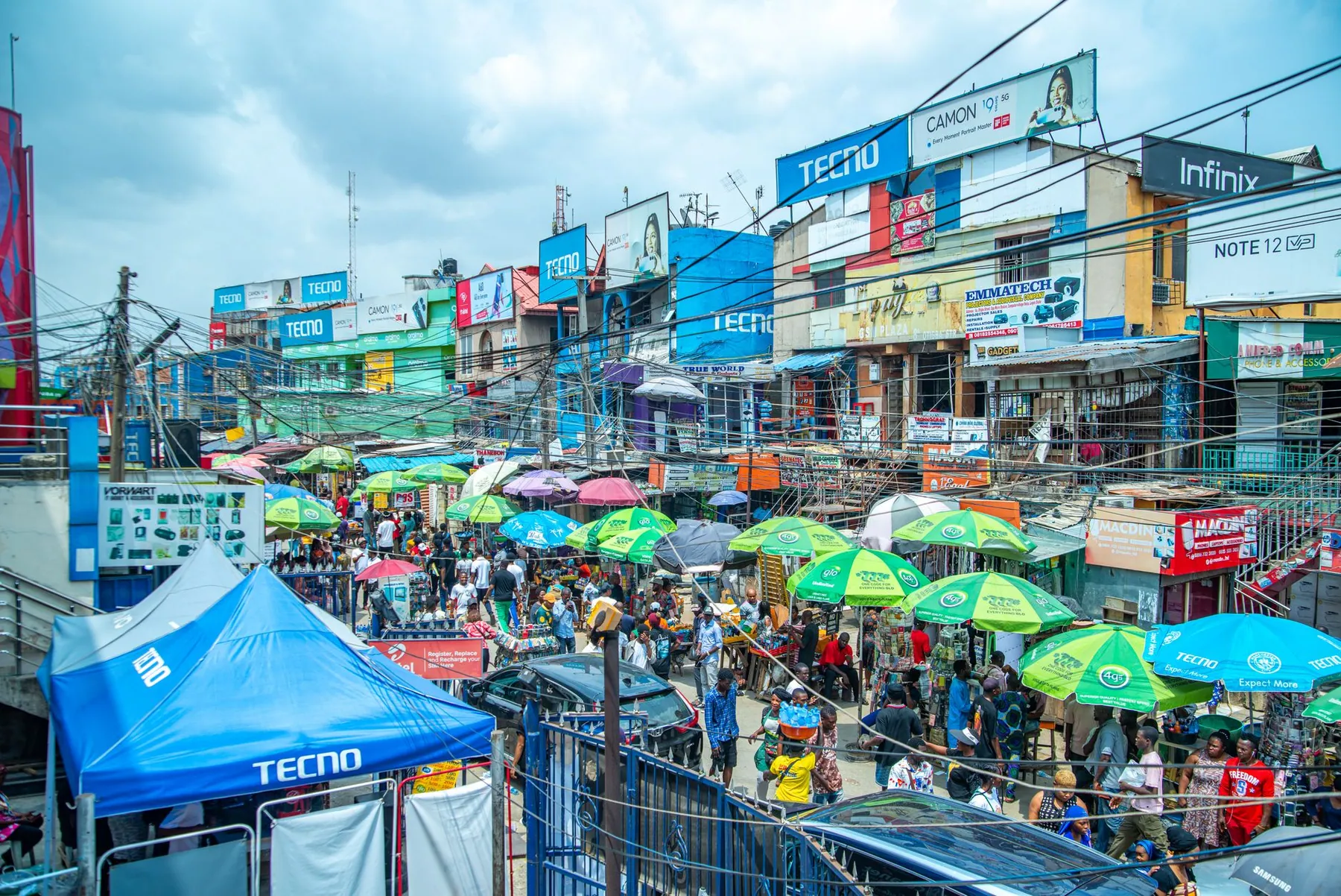 A busy Lagos market street with colourful umbrellas.