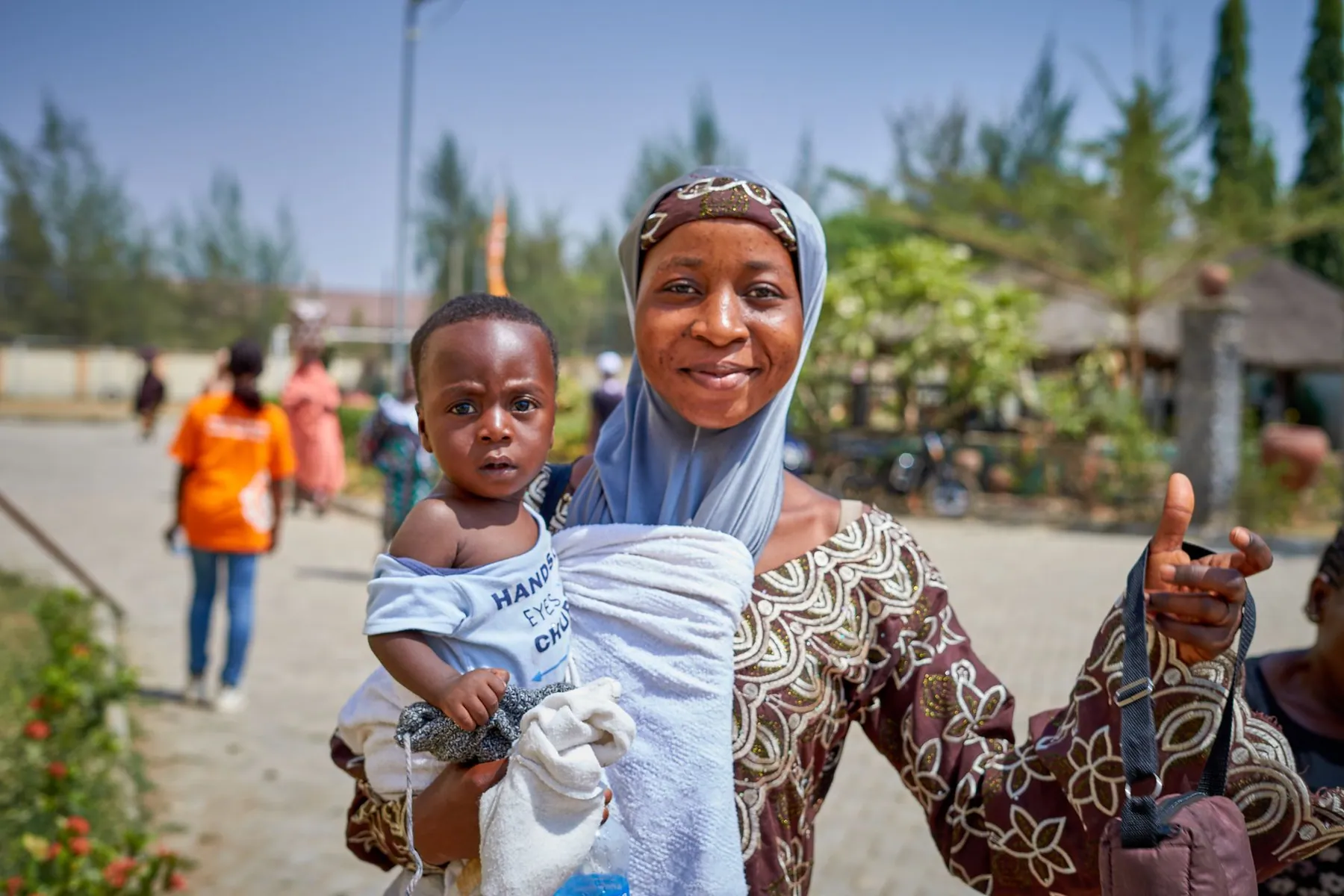 A mother holding her baby at a community health setting.