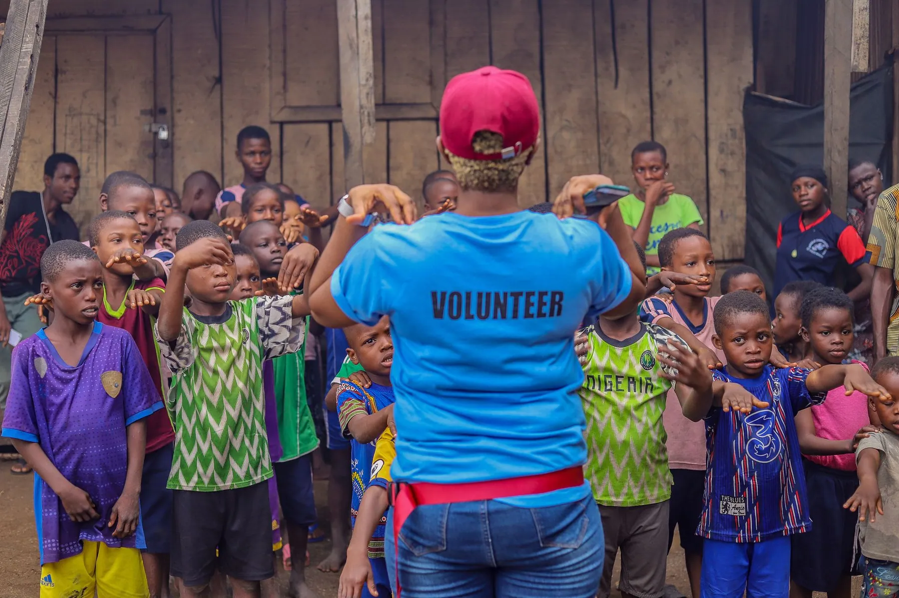 A volunteer guiding a group of children at an outreach in Lagos.