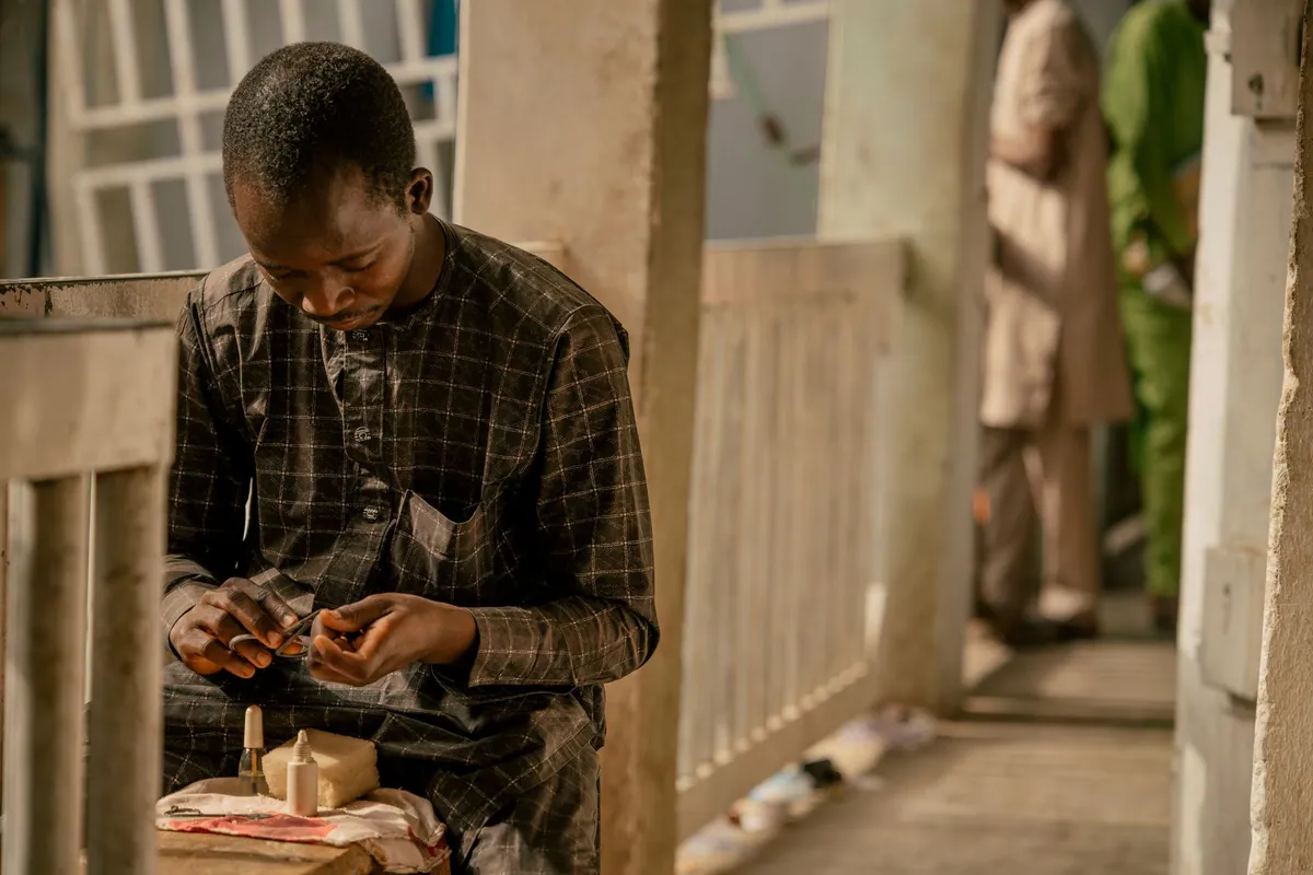 A young artisan concentrating on their craft at a workshop in Nigeria.